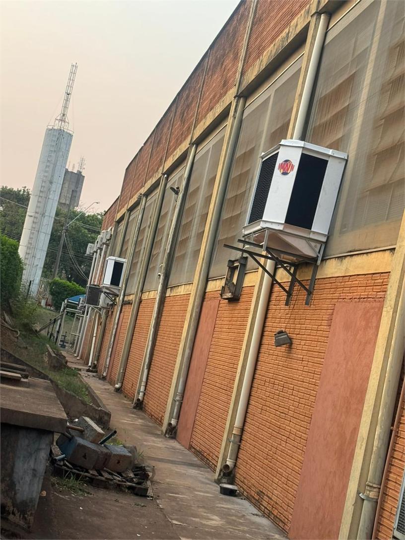 Fachada industrial de tijolo com fila de unidades presas à parede por mão francesa.